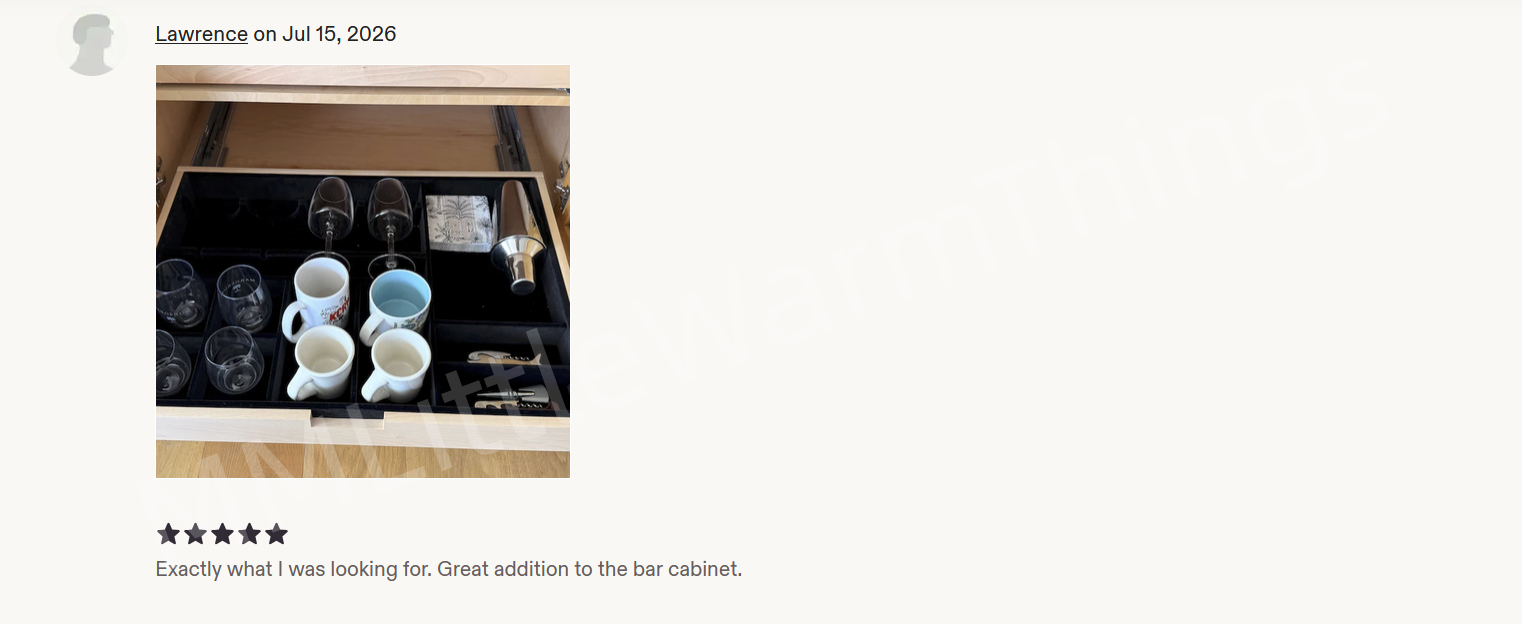 A customer review on a bar cabinet organizer, showing a photo of a glassware and mug storage tray pulled out of a wooden drawer. The review is written by 'Lawrence on Jul 15, 2026' and has five stars with a positive comment below.